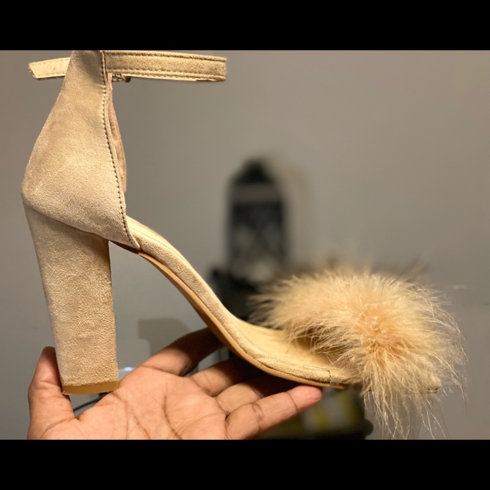 features a feather-embellished toe strap and towering heel for added drama.